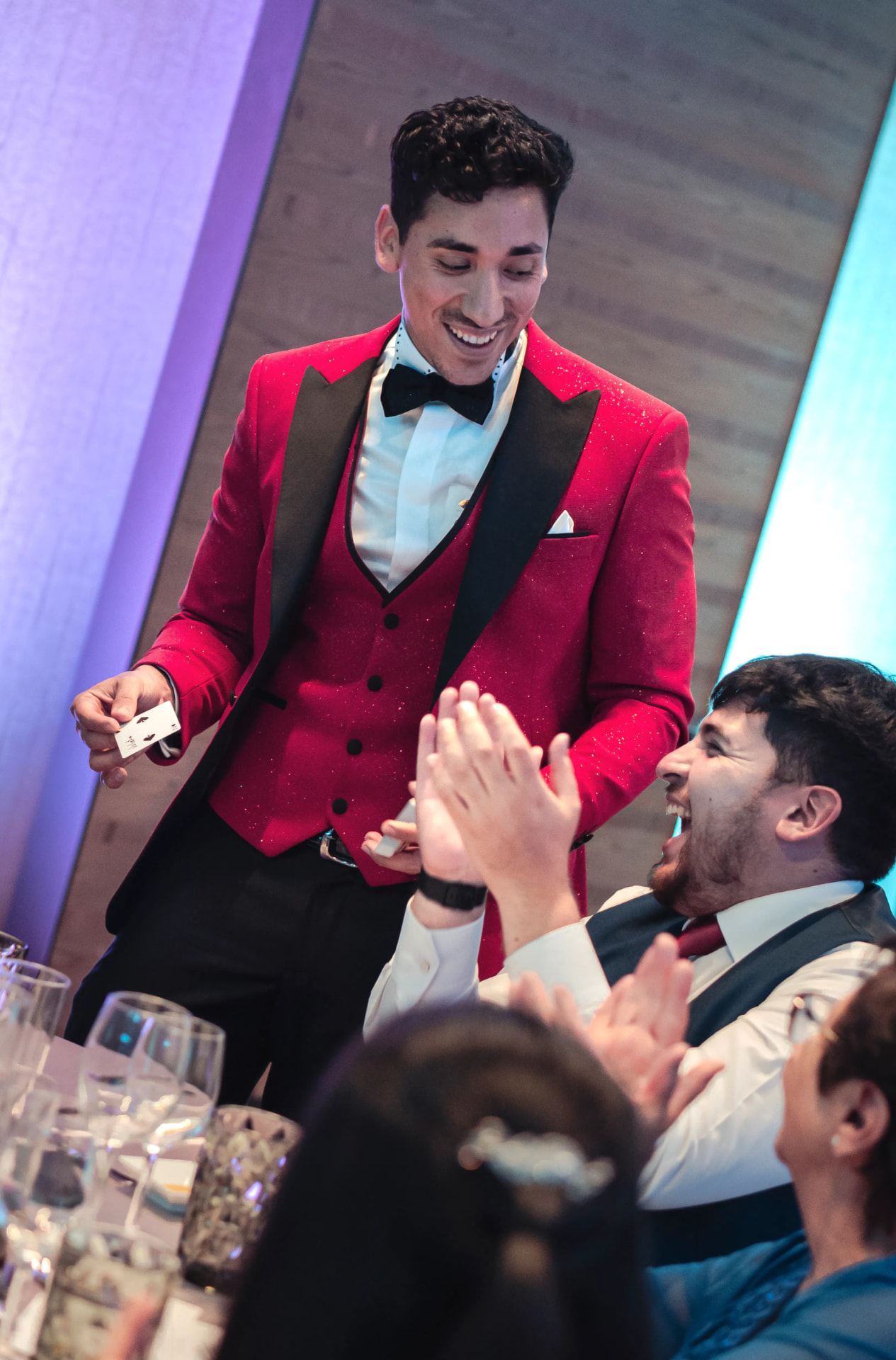 Aníbal sonriendo mientras un invitado ríe y aplaude durante la magia de cerca