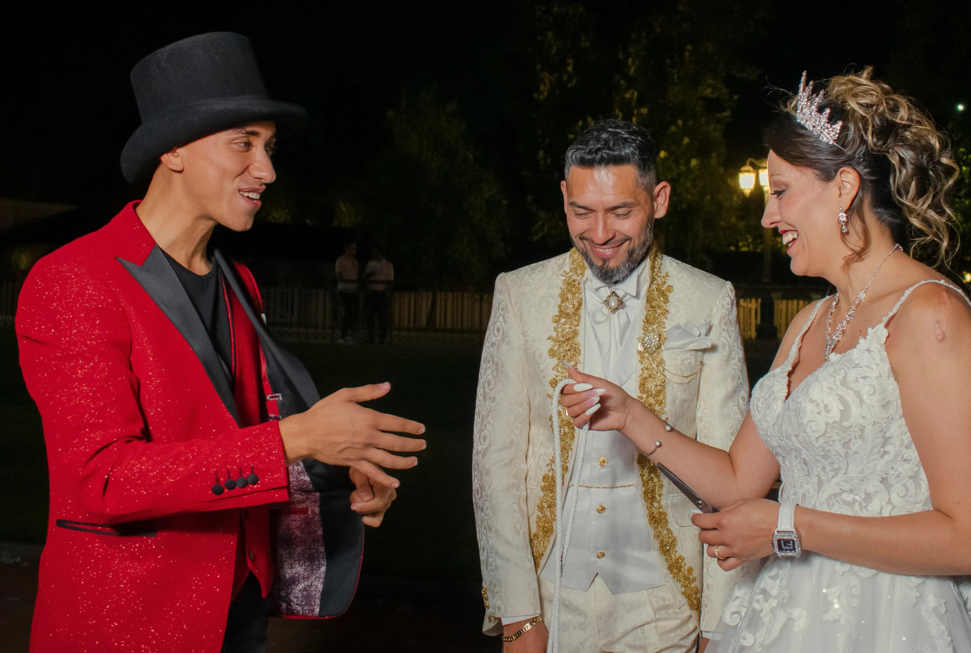 Aníbal haciendo magia junto a los novios vestidos de blanco